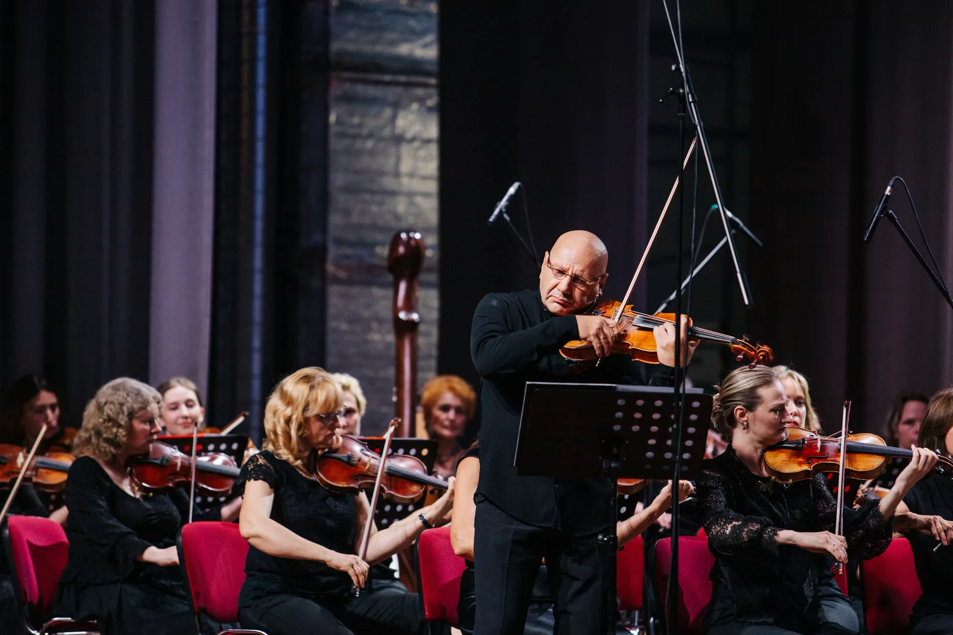Andrei Gridchuk as soloist with string orchestra, viola raised, mid-performance